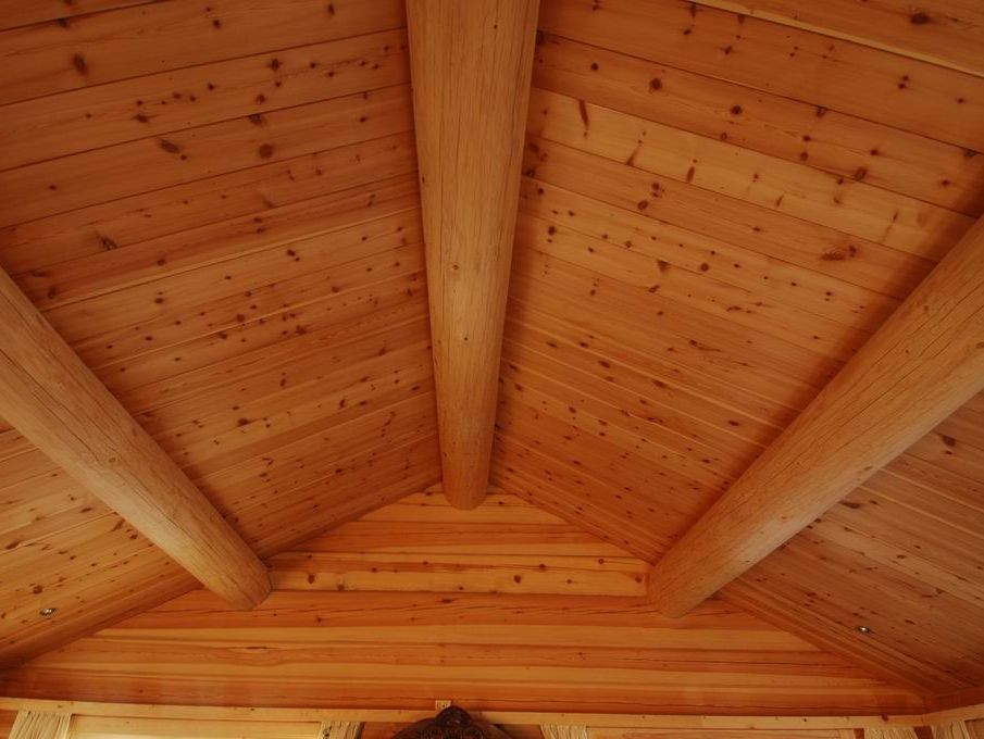 Laftet bygning med torvtak, natursteinsmur og tradisjonelle detaljer i naturnære omgivelser.